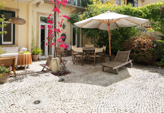 typical and warm garden in the center of Lisbon with table and chairs