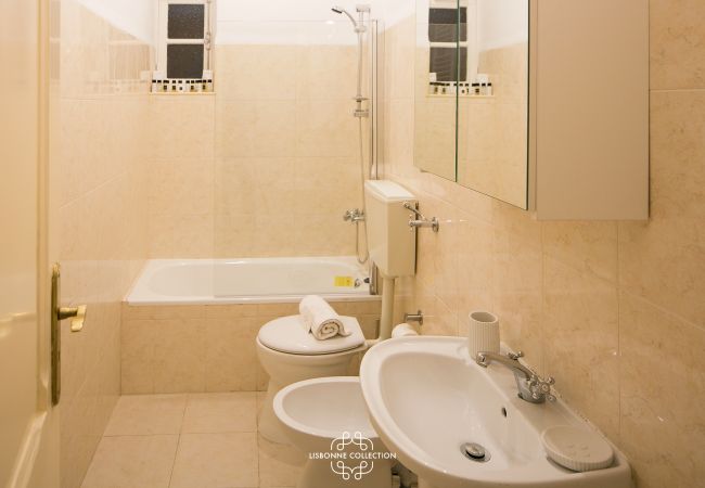beige bathroom with large bathtub, bidet and washbasin