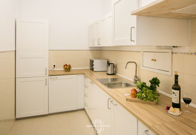 large bright kitchen with wooden worktop and bottle of wine