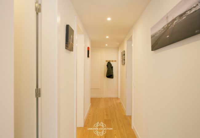 large hallway with white walls and doors and wooden floor