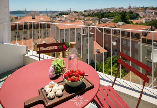 furnished terrace with red furniture and wide panorama of Lisbon